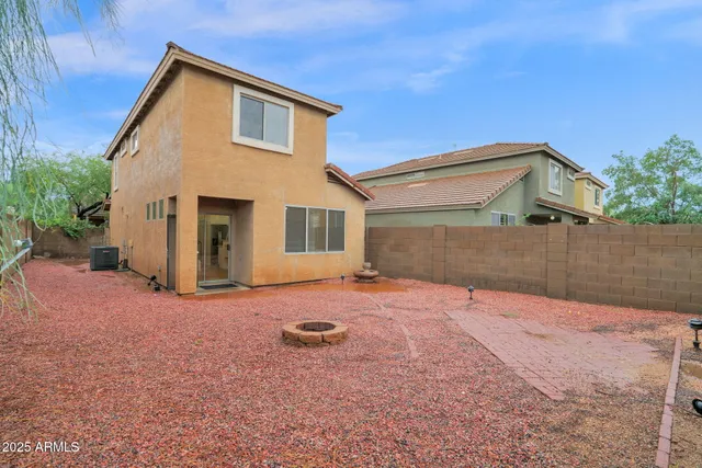 a backyard of a house with table and chairs