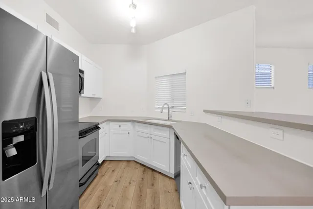 a kitchen with a sink refrigerator and window
