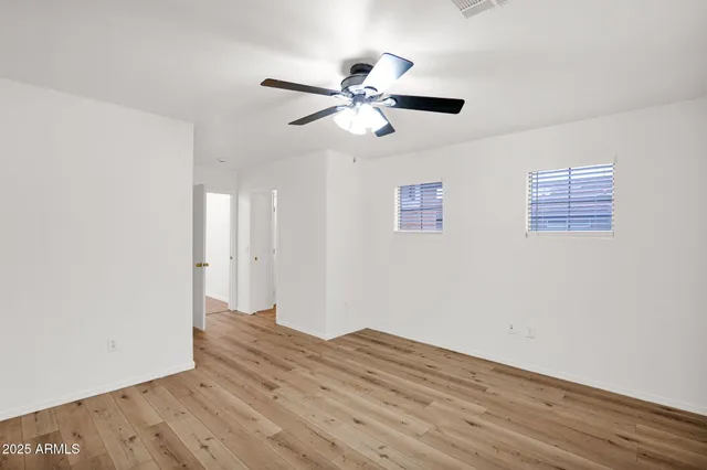 a view of empty room with wooden floor