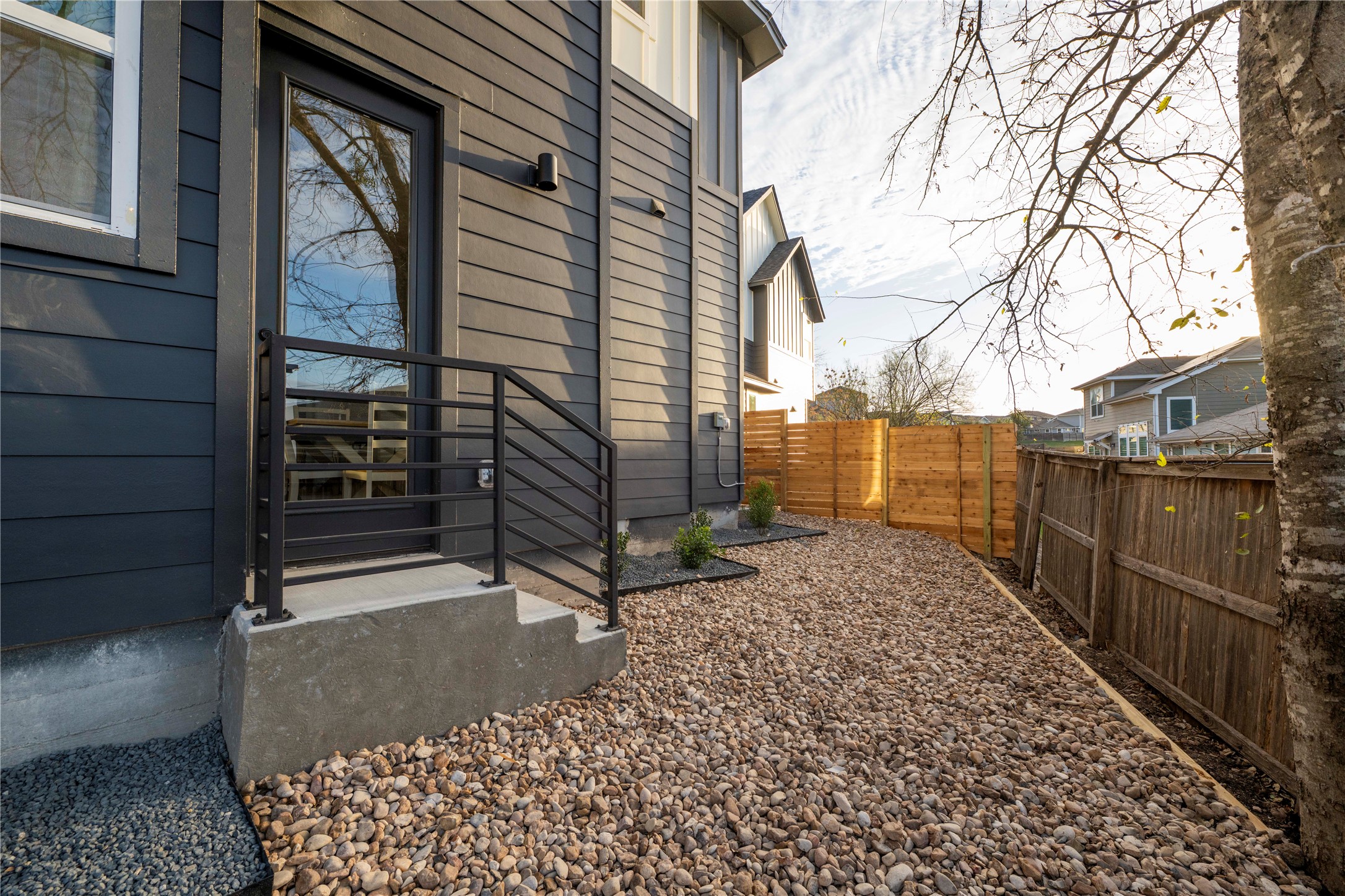 2220 Yellow Jacket Lane, Unit 1 Austin, TX 78741 - Photo 34 of 35 Securely fenced yard offers a private, low-maintenance outdoor space with modern siding and entry.