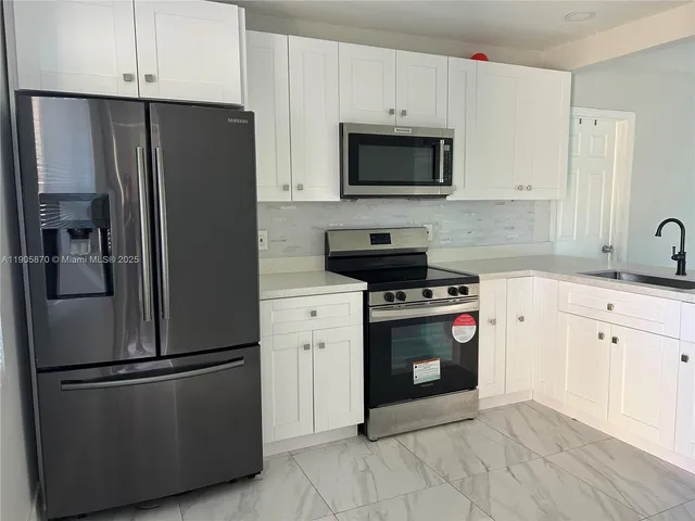 a kitchen with stainless steel appliances a refrigerator stove and microwave