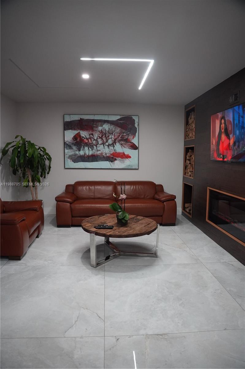 19262 Northwest 89th Avenue Hialeah, FL 33018 - Photo 17 of 20 a living room with furniture a flat screen tv and a fireplace