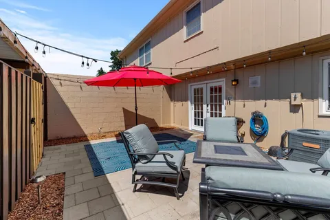 a view of a patio with a table and chairs under an umbrella