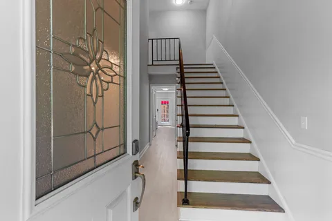 a view of entryway and hall with wooden floor