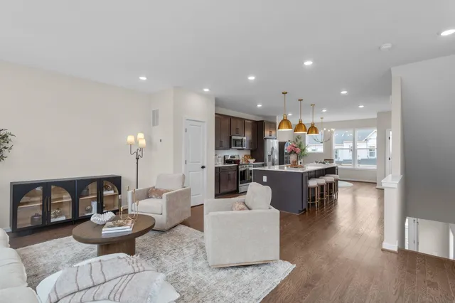 a living room with furniture and a dining table with wooden floor