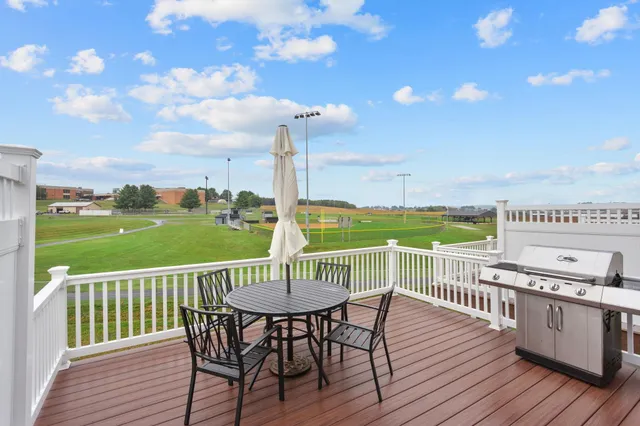 a view of a deck with a table and chairs with wooden floor and fence