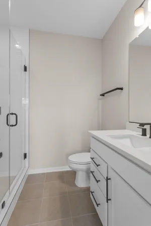 a bathroom with a granite countertop sink a toilet and a shower