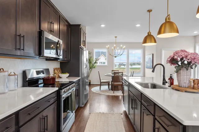 a kitchen with stainless steel appliances granite countertop a sink stove and cabinets