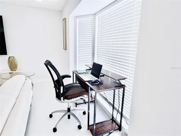 a living room with furniture and a dining table with kitchen view