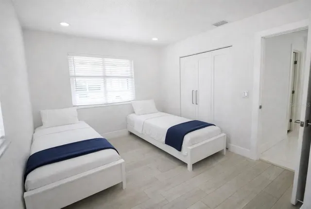 a view of a white house with a large space in front of it