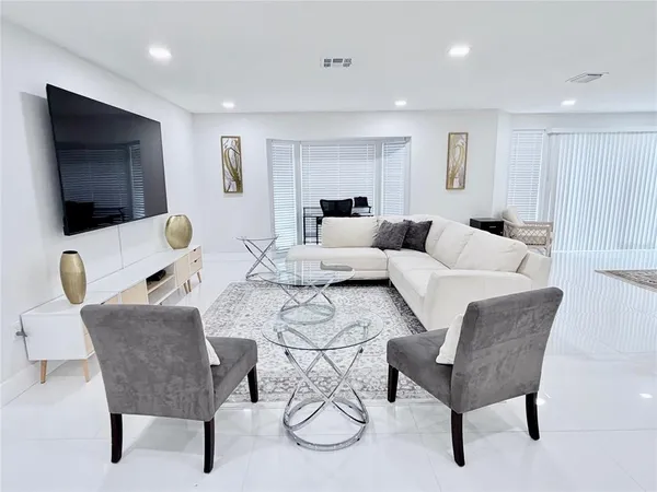a living room with furniture and wooden floor