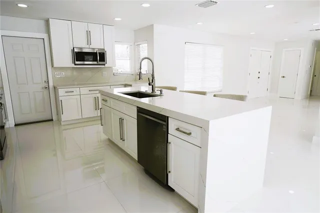 a kitchen with stainless steel appliances a refrigerator sink and cabinets