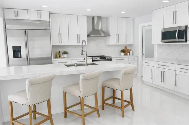 a kitchen with stainless steel appliances kitchen island granite countertop a sink and cabinets