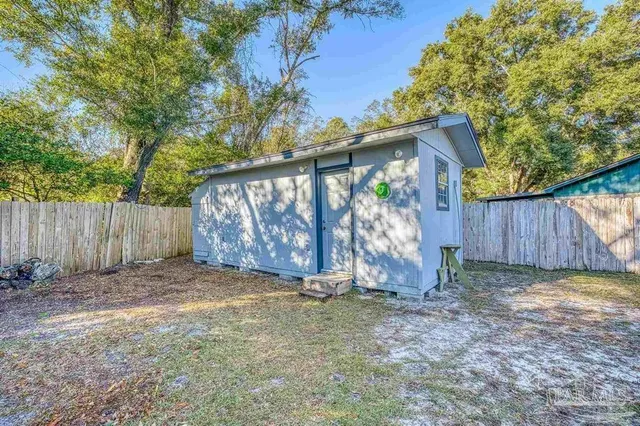 a view of a backyard with a small cabin and a chair