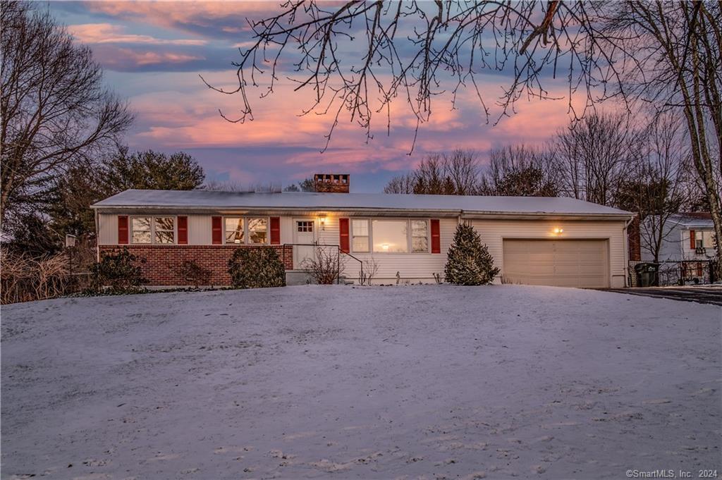 front view of house with a yard and palm trees