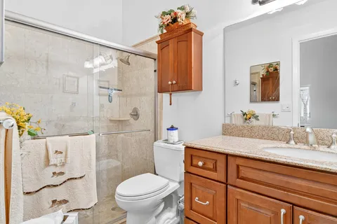 a bathroom with a granite countertop sink toilet and shower