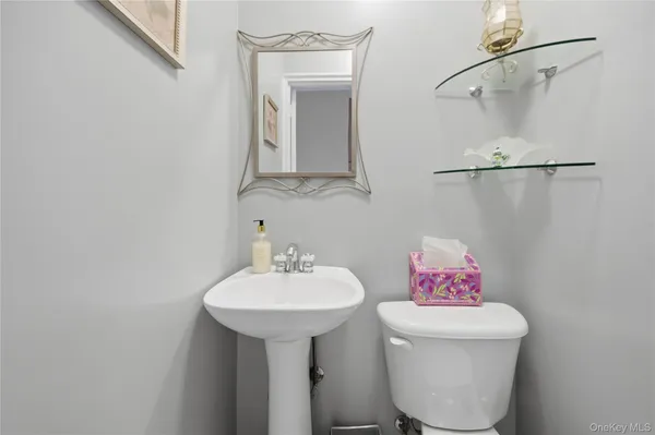 a bathroom with a sink toilet and a mirror