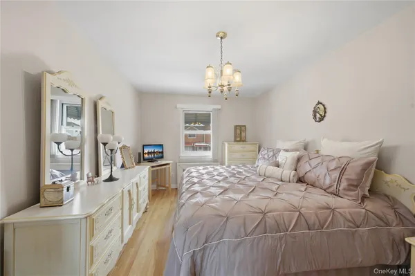 a spacious bedroom with a bed and a chandelier