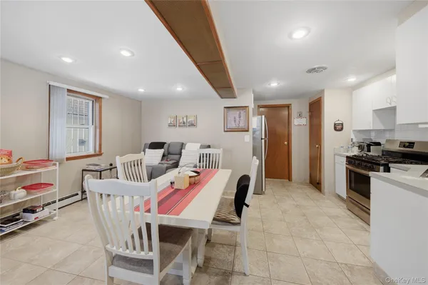 a dining room with furniture and kitchen view