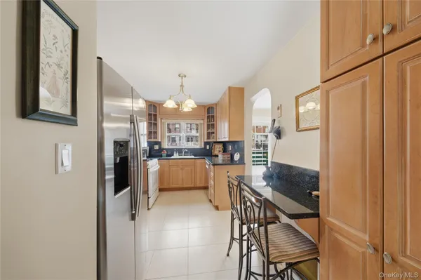a kitchen with stainless steel appliances refrigerator dining table and chairs