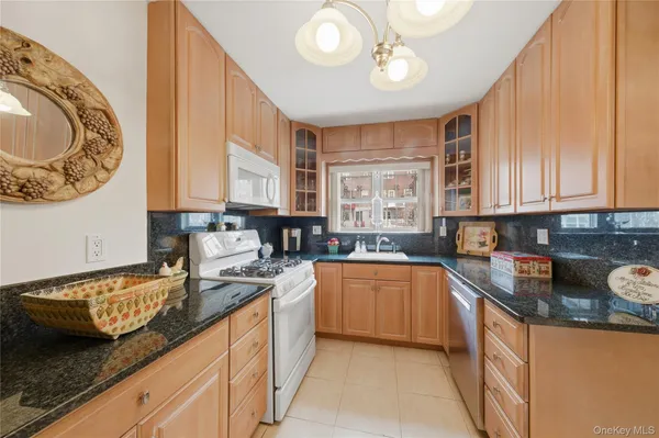 a kitchen with granite countertop a sink a stove and cabinets