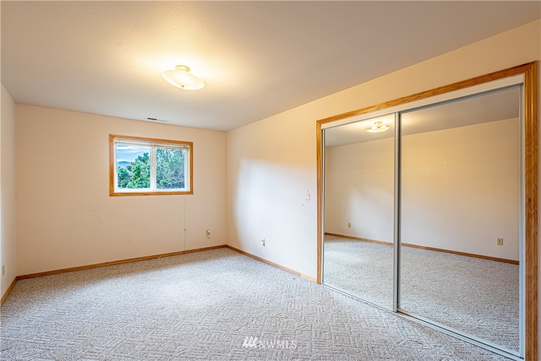 755 Wapato Way Manson, WA 98831 - Photo 27 of 40 an empty room with a sliding door and windows