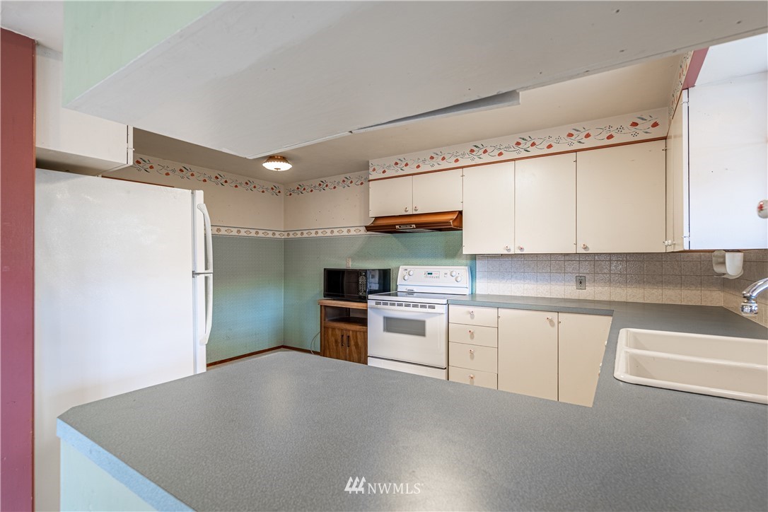 755 Wapato Way Manson, WA 98831 - Photo 7 of 40 a kitchen with stainless steel appliances a refrigerator sink and cabinets