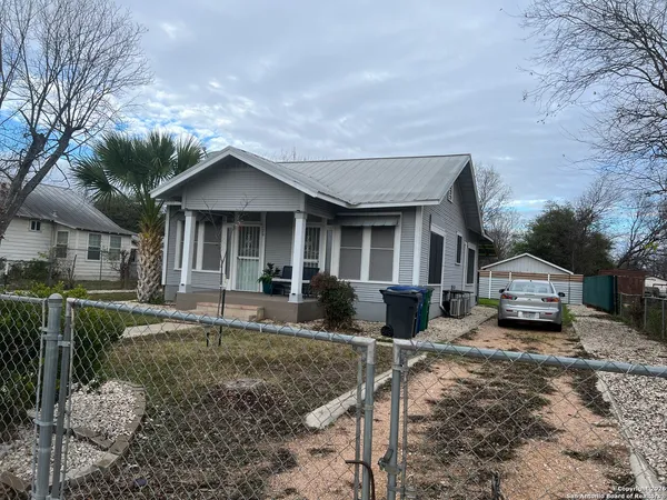 a front view of a house with cars parked