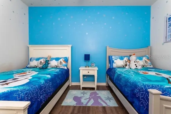 a bedroom with a bed and a lamp on dresser