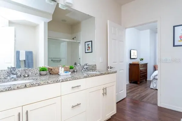 a spacious bathroom with a double vanity sink and mirror