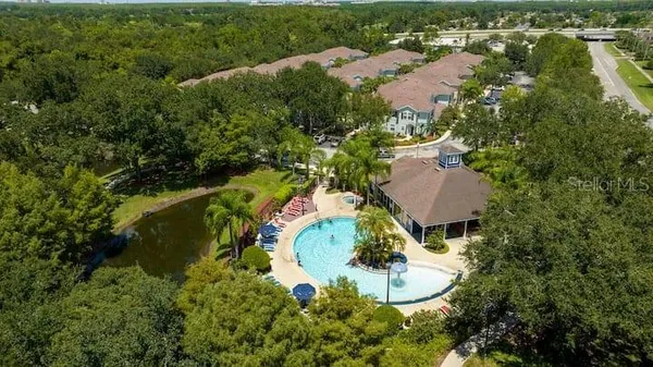 an aerial view of residential house with outdoor space and trees all around