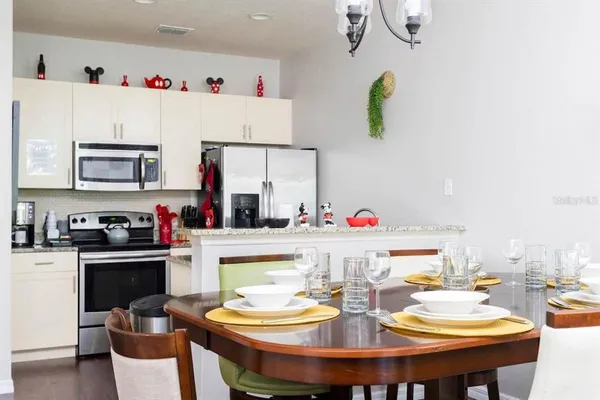 a kitchen with a dining table cabinets and appliances