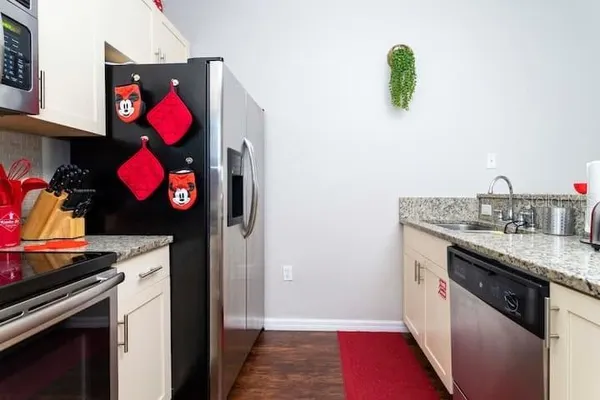 a kitchen with stainless steel appliances granite countertop a stove a sink and a microwave