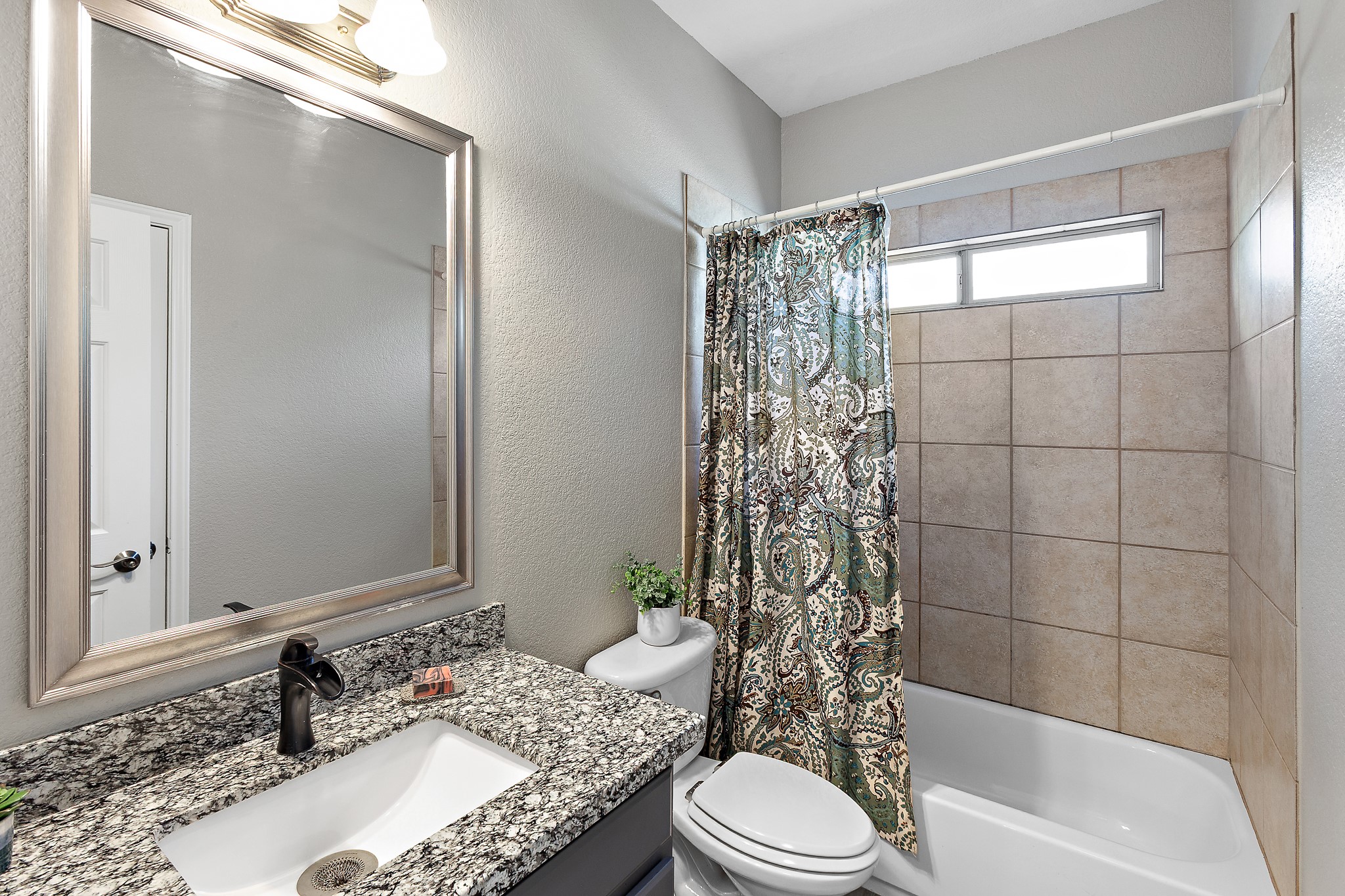 914 Bret Lane Austin, TX 78721 - Photo 19 of 33 a bathroom with a granite countertop bathtub sink vanity mirror and toilet