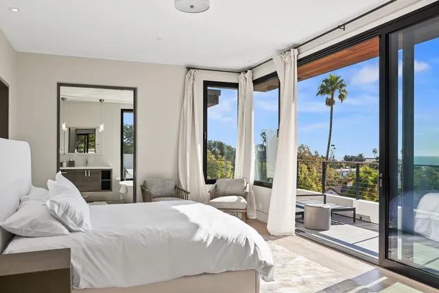 a bedroom with a large bed and a painting on the wall