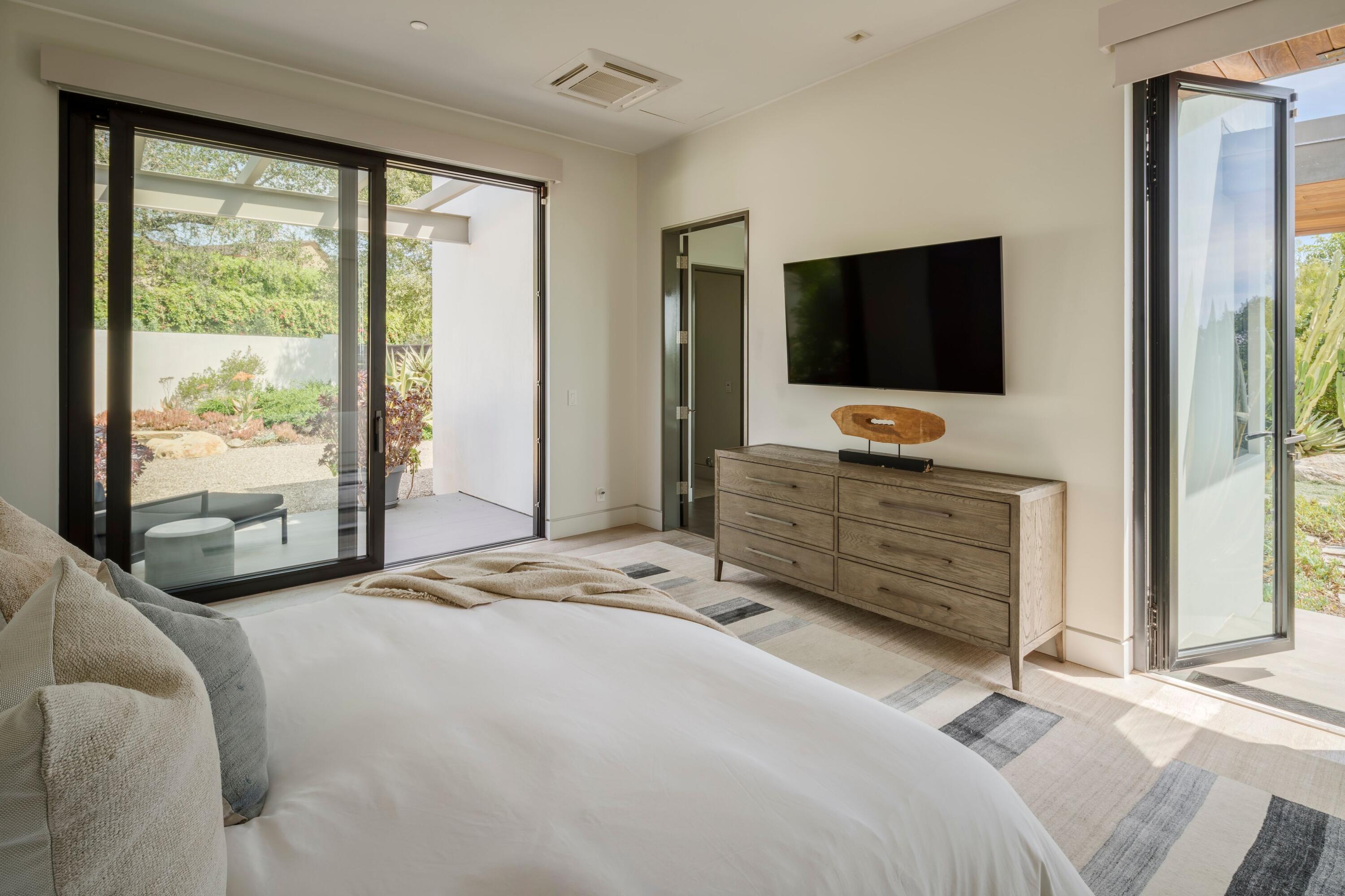 1131 Las Alturas Road, Unit A Santa Barbara, CA 93103 - Photo 23 of 47 a bedroom with a large bed and a flat screen television