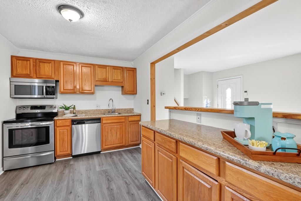 4703 North Springs Road Northwest Kennesaw, GA 30144 - Photo 15 of 35 a kitchen with stainless steel appliances granite countertop a stove a sink and a microwave
