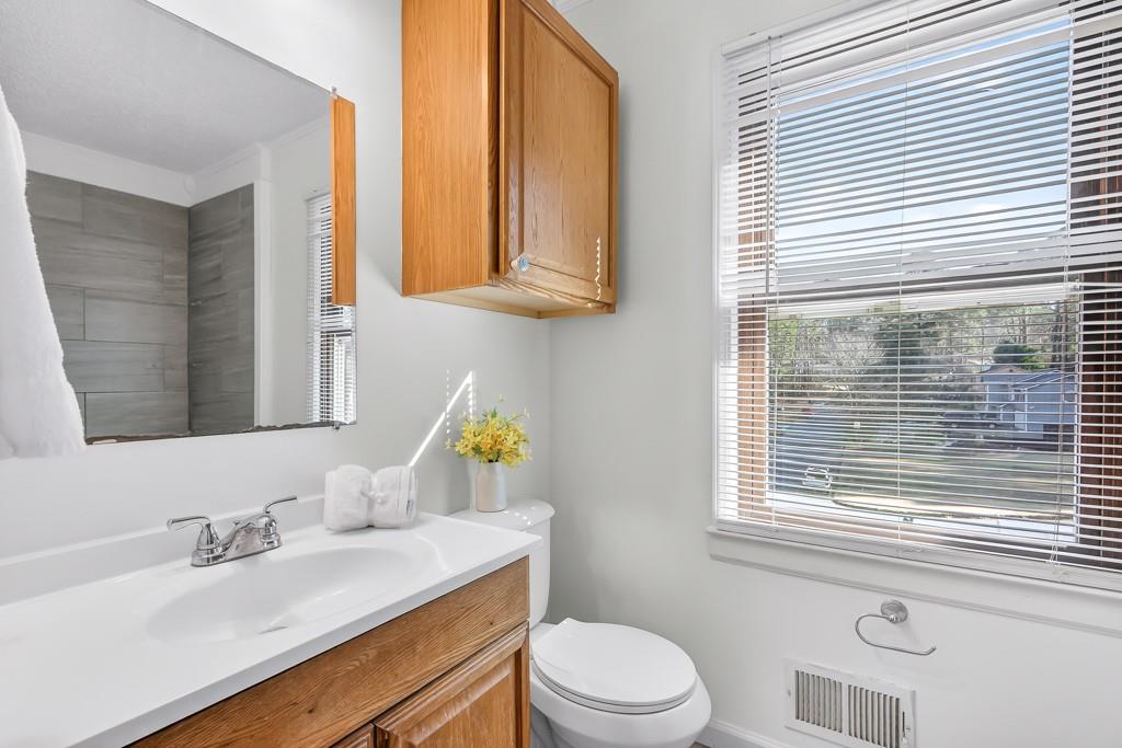 4703 North Springs Road Northwest Kennesaw, GA 30144 - Photo 19 of 35 a bathroom with a sink a toilet and a window