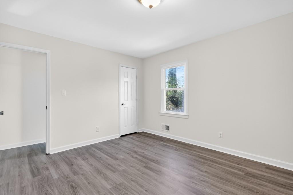 4703 North Springs Road Northwest Kennesaw, GA 30144 - Photo 22 of 35 a view of an empty room with wooden floor and a window