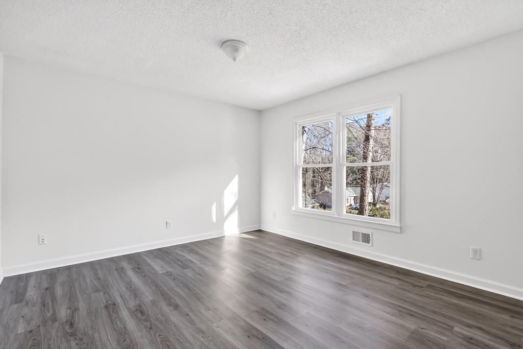 4703 North Springs Road Northwest Kennesaw, GA 30144 - Photo 23 of 35 an empty room with wooden floor and windows