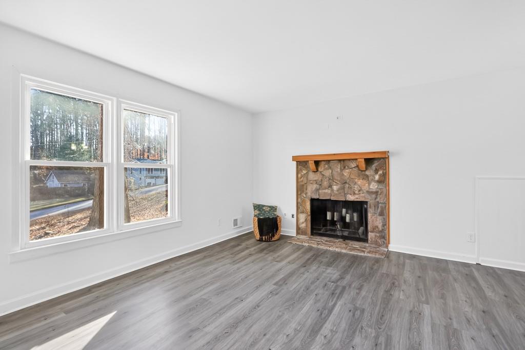 4703 North Springs Road Northwest Kennesaw, GA 30144 - Photo 7 of 35 a view of an empty room with wooden floor fireplace and a window