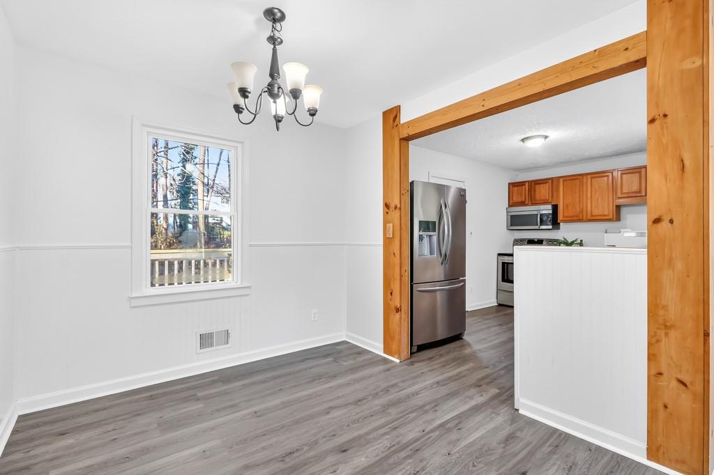 4703 North Springs Road Northwest Kennesaw, GA 30144 - Photo 10 of 35 a view of a hallway with wooden floor and a kitchen