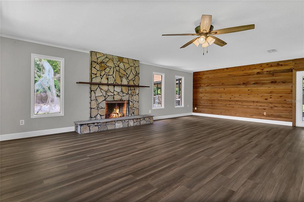 9 Sunny Road Ormond Beach, FL 32174 - Photo 4 of 33 a view of an empty room with wooden floor fireplace and a window