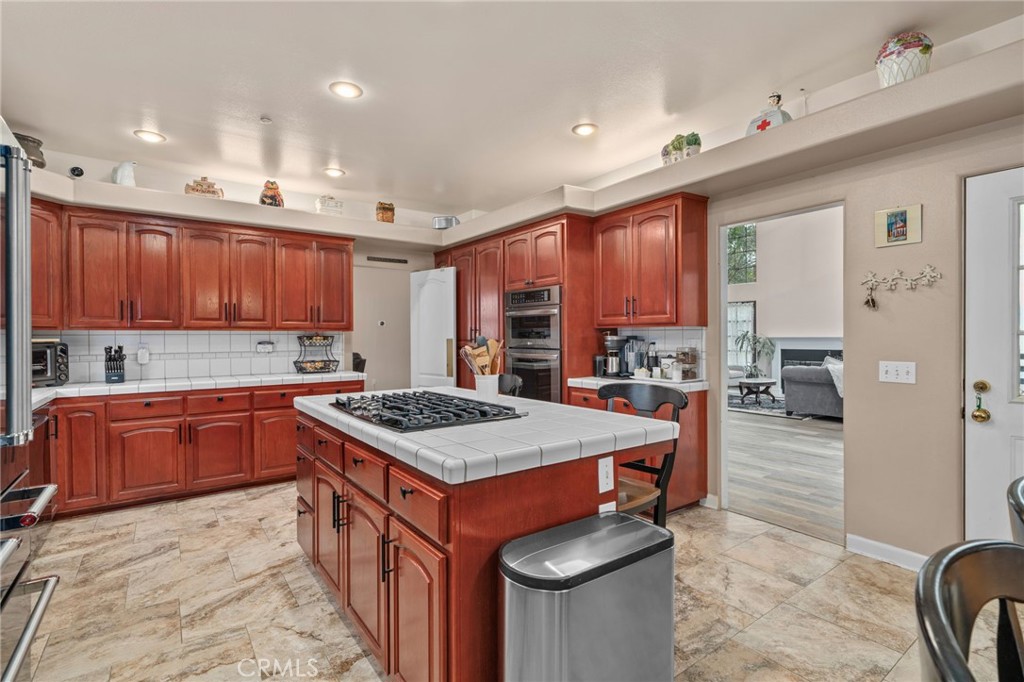334 Lakeside Avenue Redlands, CA 92373 - Photo 15 of 63 a kitchen with stainless steel appliances granite countertop a stove top oven a sink dishwasher and a refrigerator with wooden cabinets
