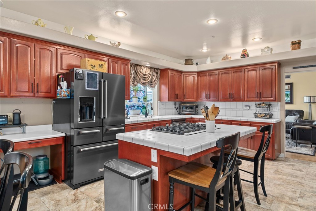 334 Lakeside Avenue Redlands, CA 92373 - Photo 16 of 63 a kitchen with a refrigerator a stove a sink and a dining table with wooden cabinet