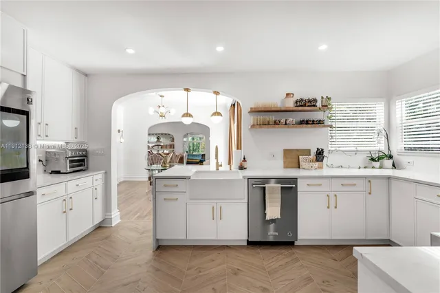 a kitchen with white cabinets and sink