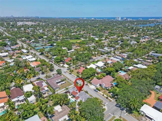 an aerial view of residential houses with outdoor space and trees