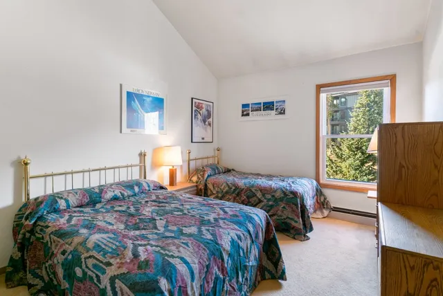 a bedroom with a bed next to a window with a tv