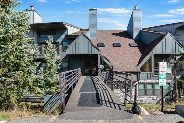 a roof deck with table and chairs under an umbrella