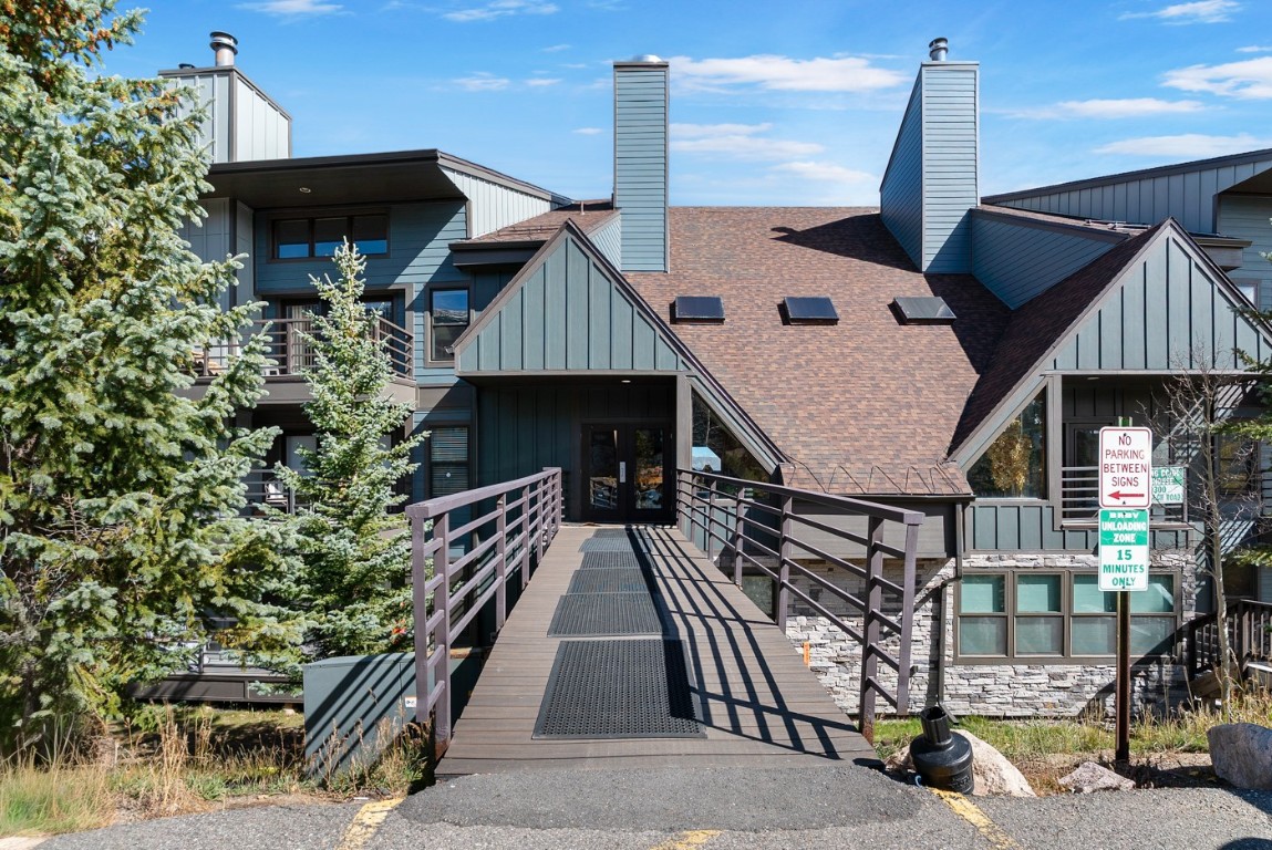 89310 Ryan Gulch Road, Unit 409 Silverthorne, CO 80498 - Photo 20 of 21 a roof deck with table and chairs under an umbrella